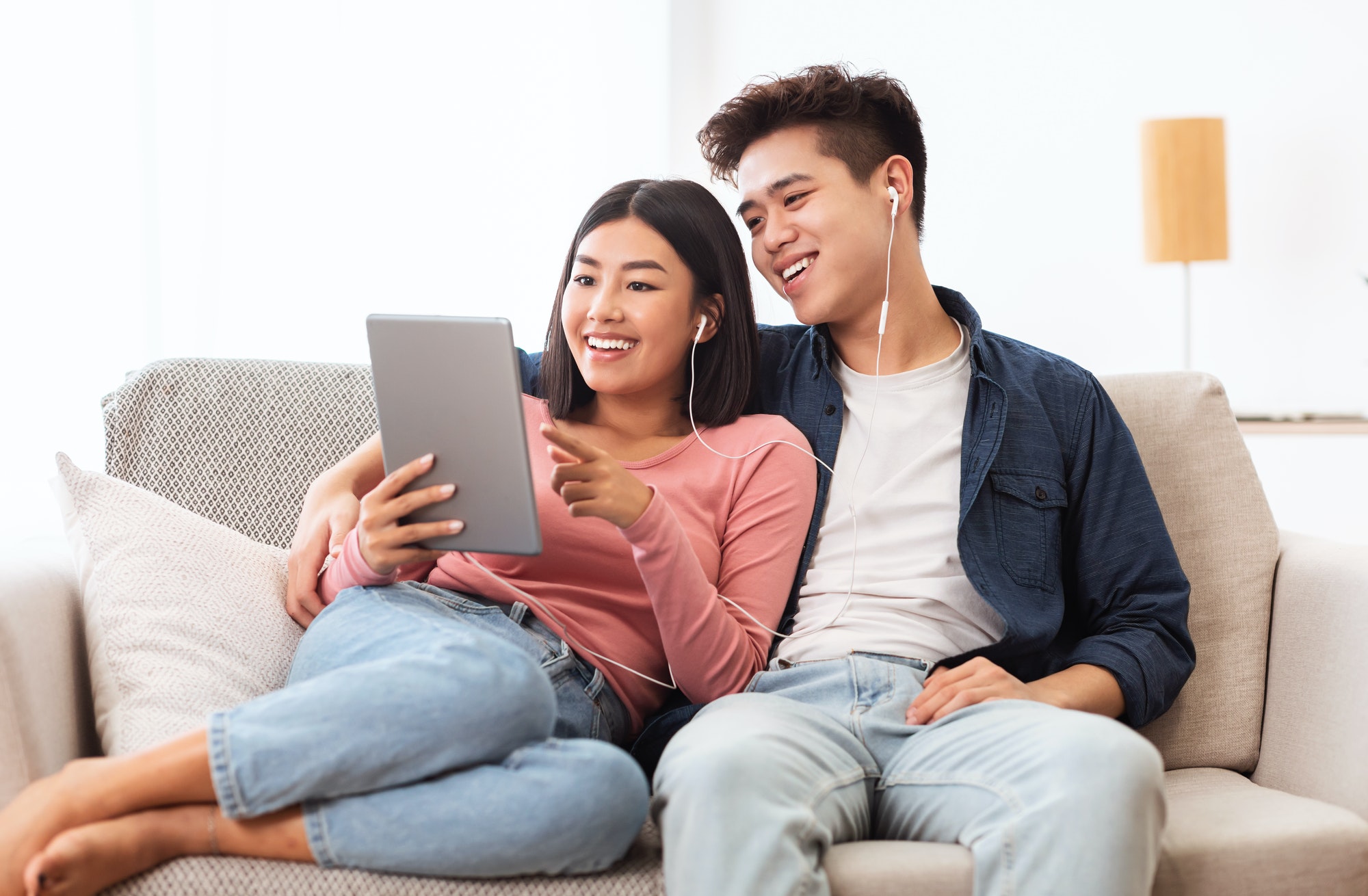 cheerful-asian-couple-using-digital-tablet-browsing-internet-at-home